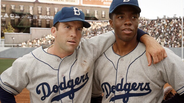 alt="42 movie still with Chadwick Boseman in Dodgers uniform with teammate"