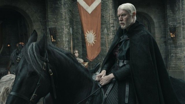 alt="Sam Spruell as Prince Maekar Targaryen riding a black horse through a courtyard in A Knight of the Seven Kingdoms."