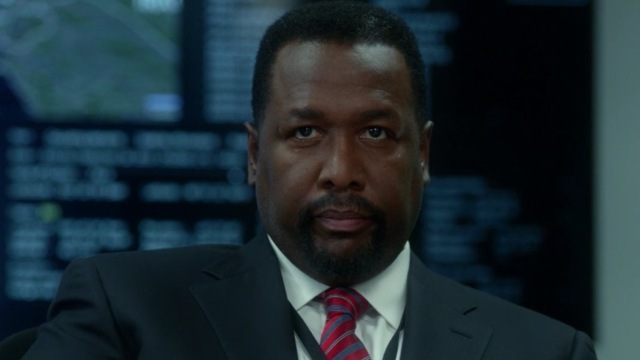 Wendell Pierce as James Greer staring ahead with computers behind him